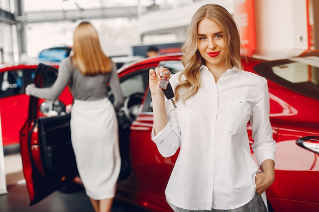 Twee stijlvolle vrouwen in een autosalon