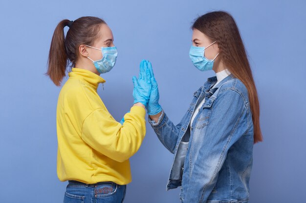 Twee vrienden zijn casual kleding, medische maskers en latexhandschoenen