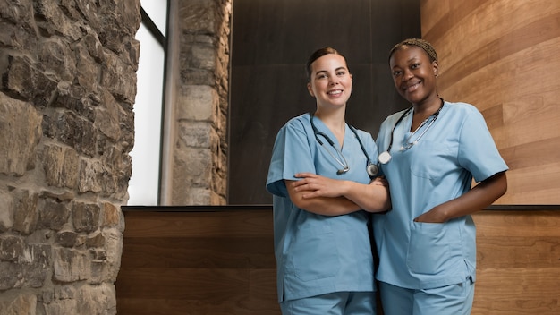 Twee vrouwelijke verpleegsters werken in de kliniek in scrubs