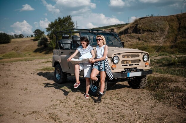 Twee vrouwen die de kaart controleren terwijl ze met de auto reizen