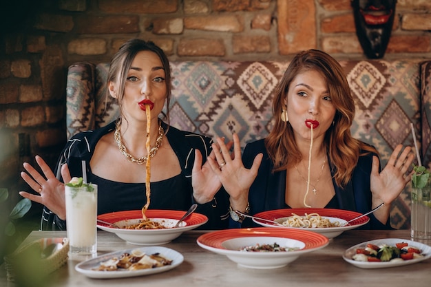 Twee vrouwen die deegwaren in een italiaans restaurant eten