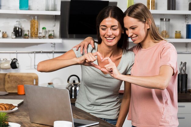 Twee vrouwen die thuis hart tonen tijdens videochatten