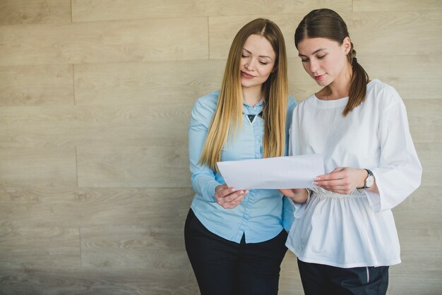 Twee vrouwen kijken naar een papier