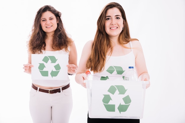 Twee vrouwen kringloopaanplakbiljet en krat houden tegen witte achtergrond