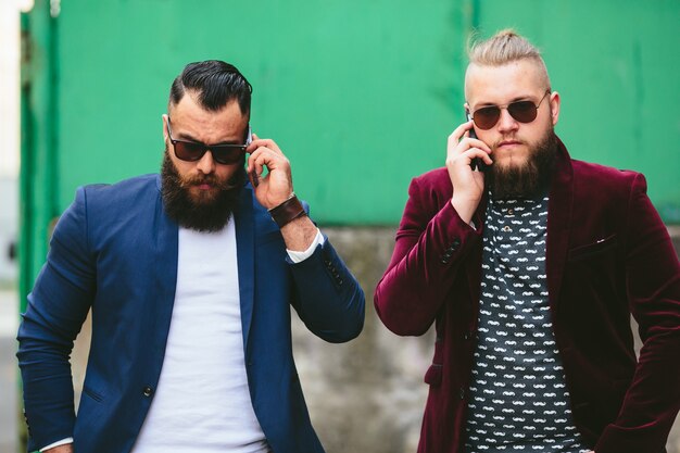 Twee zakenlieden praten aan de telefoon in de stad