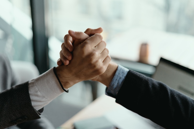 Gratis Foto twee zakenmannen vieren een deal