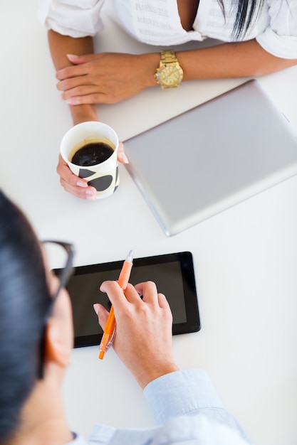 Gratis foto twee zakenvrouw werken in kantoor met digitale tablet.