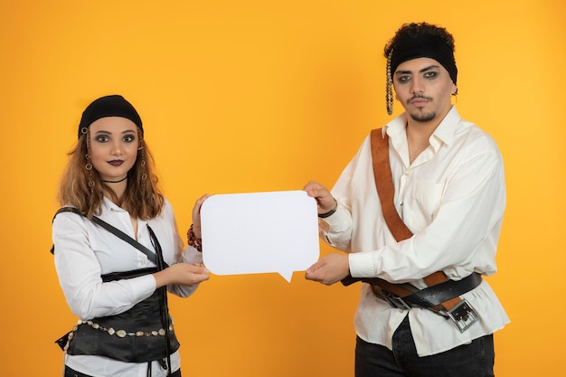 Twee zelfverzekerde piraten die een ideebord houden en naar de camera kijken. Hoge kwaliteit foto