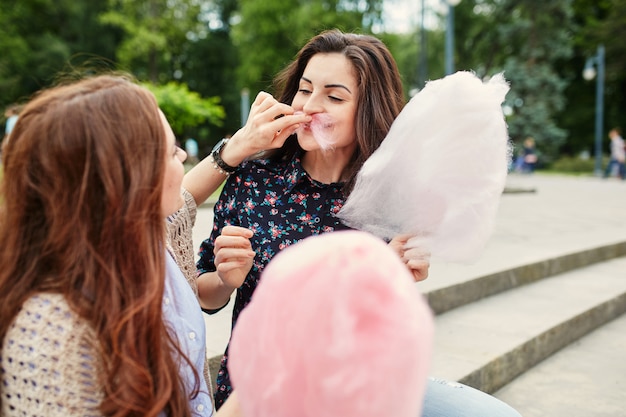 Twee zussen suikerspin eten in het park