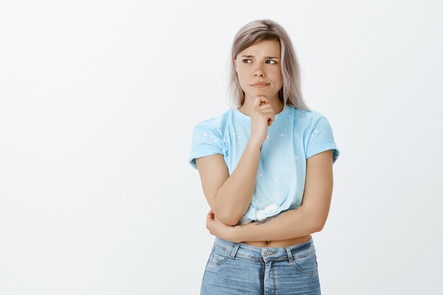 Twijfelachtig blond meisje poseren in de studio