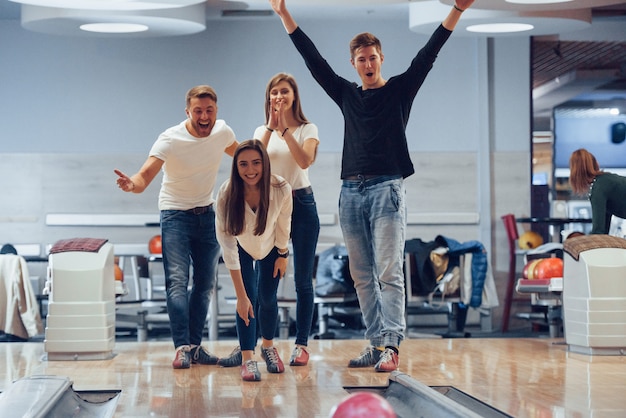 U kunt de aanval maken. Jonge, vrolijke vrienden vermaken zich in het weekend in de bowlingclub