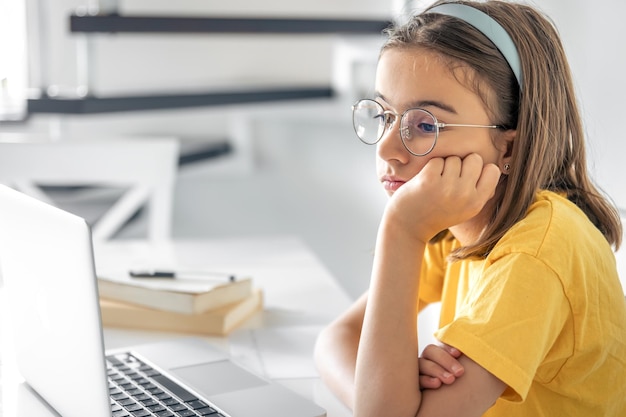 Uitgeput schoolmeisje dat lijdt aan huiswerk, moe van het studeren.