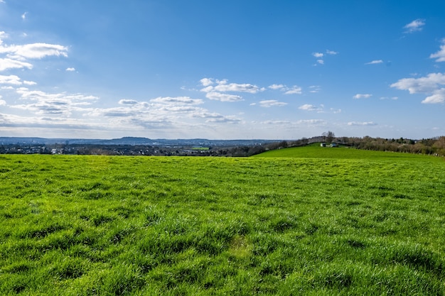 Uitgestrekte groene vallei met overdag een blauwe lucht