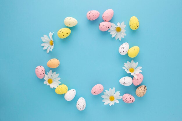 Uitnodiging voor Pasen met eieren en madeliefjes op een blauwe achtergrond met kopie ruimte