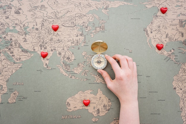 Uitstekende wereldkaart met kompas en decoratieve rode harten