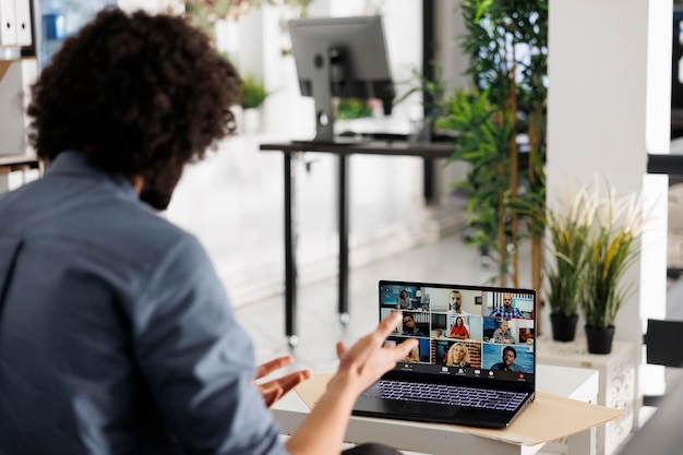 Uitvoerend directeur bespreekt de startstrategie van het project met collega's tijdens een videogesprek op een laptop. Zakenman werkt samen met een remote team via een virtuele vergadering op een draagbaar computerscherm