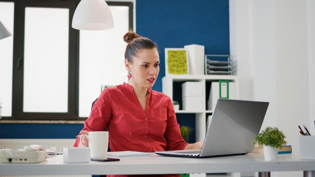 Uitvoerend manager die aantekeningen maakt over financiële documenten om gegevensgrafieken met verkoopstatistieken te maken. Accountant die onderzoeksdocumenten analyseert en rapporteert over laptop voor bedrijfsontwikkeling.