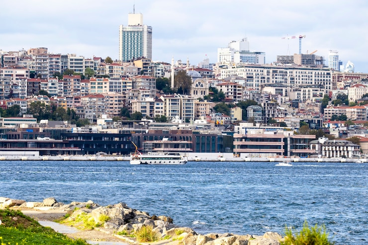 Gratis Foto uitzicht op een wijk met residentiële en hoge moderne gebouwen in istanbul, bosporus met boten, mensen rusten op de kust, turkije