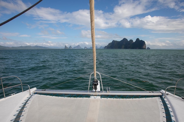 Uitzicht op het blauwe zeewater vanaf de zijkant van een zeilboot met tuigage en zeilen. tackle aak, zeil, masten, werven, dek, touwen
