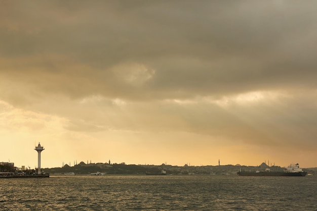 Uitzicht op het oude historische gebouw met moskeeën torens gebouwen in de oostelijke stijl vrachtschepen sleepboten in de haven op de rede op de achtergrond van bewolkte hemel