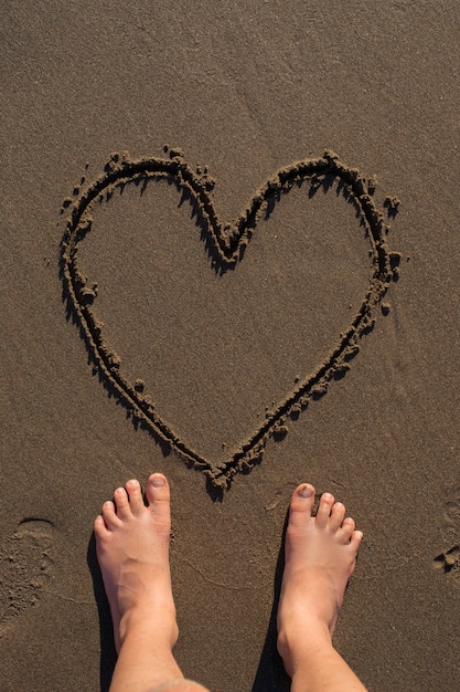 Uitzicht op het zand op het strand in de zomer met een boodschap erin geschreven