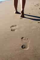 Gratis foto uitzicht op het zand op het strand in de zomer met voetafdrukken