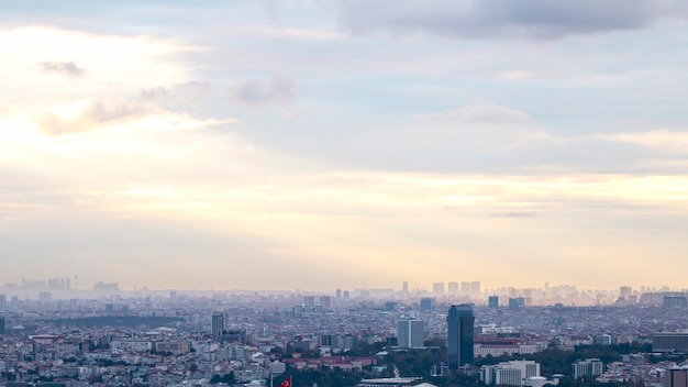 Uitzicht op Istanbul bij bewolkt weer, meerdere lage en hoge gebouwen, mist en zonlicht dat door de wolken breekt, Turkije