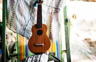 Gratis foto ukelele op ligstoel op de strandvakantie