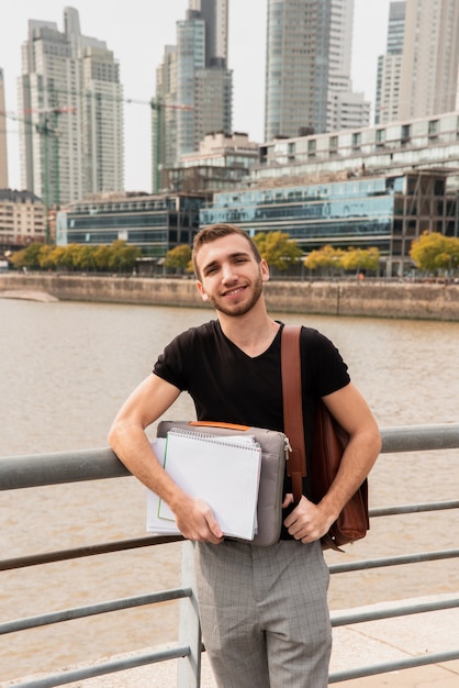 Universitaire student in een grote stad die zijn nota's houdt