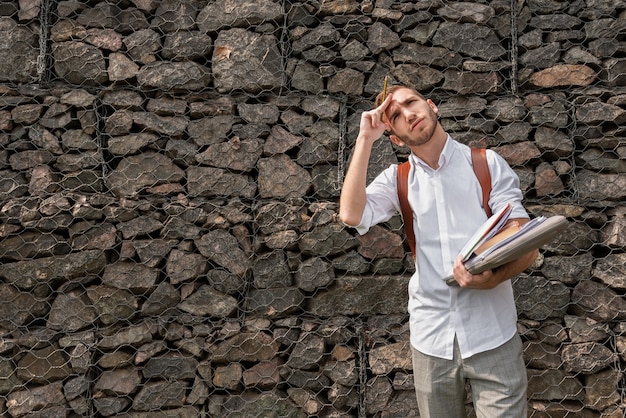 Universitaire studentenmappen van boeken en nota's houden en omhoog het kijken