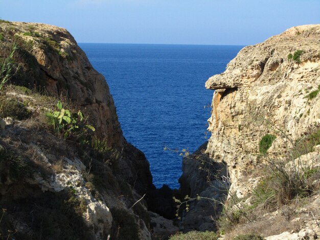 V-vormige rots en een heldere zee overdag in Wied il-Mielah, Gharb, Gozo, Maltese eilanden