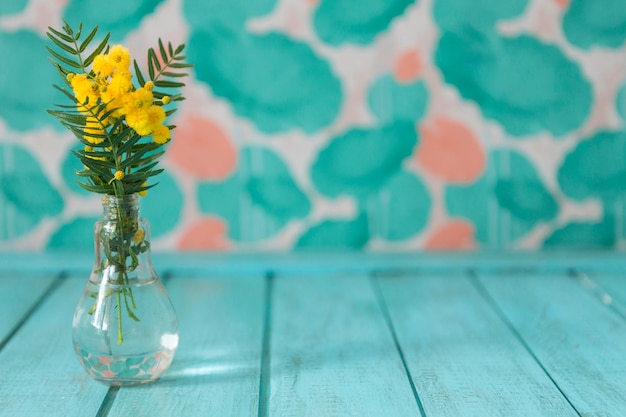 Gratis foto vaas met bloemen op blauwe houten ondergrond