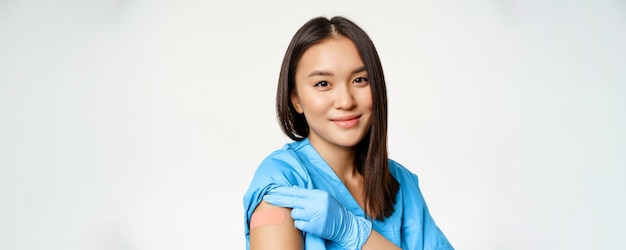 Vaccinatieprogramma en covid concept portret van Aziatische gezondheidswerker in medische mantel met va