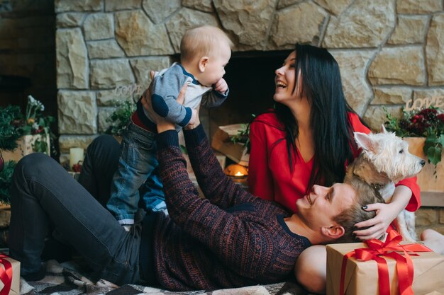 Vader bedrijf baby omhoog terwijl zijn vrouw kijkt naar hen