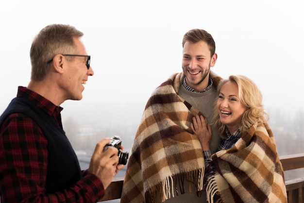 Gratis foto vader die beeld van smileyzoon en moeder neemt