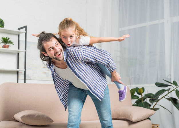 Vader die een ritje op een piggy-back geeft aan zijn dochter