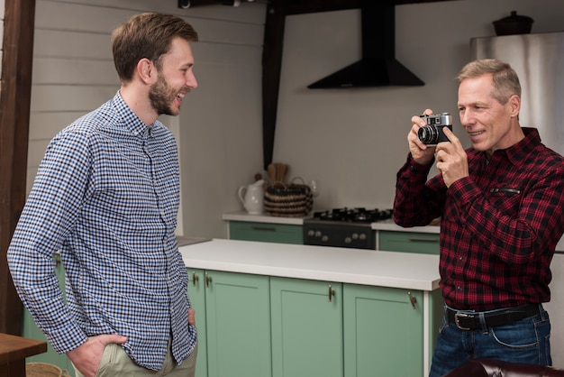 Vader die foto's van gelukkige zoon in de keuken neemt