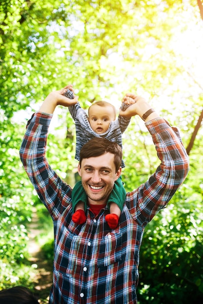 Gratis foto vader die jongen op schouders houdt