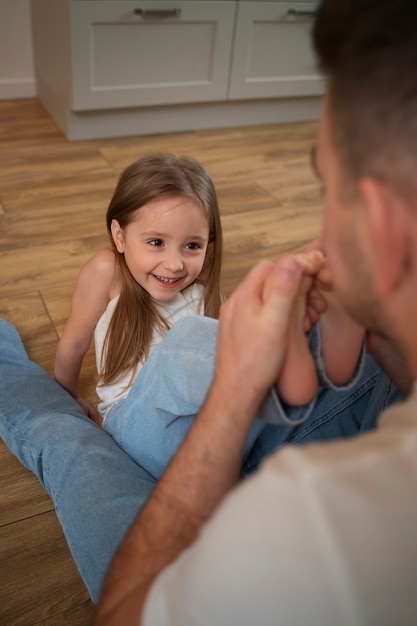 Gratis foto vader die zijn dochter aan het lachen maakt door haar te kietelen