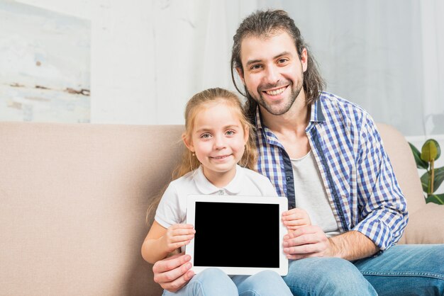 Vader en dochter die de tablet tonen