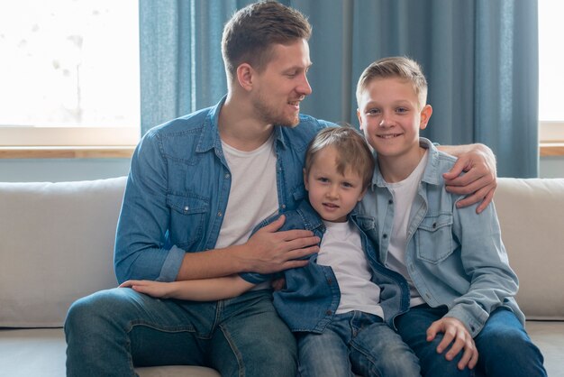 Vader en schattige broers zittend op de Bank