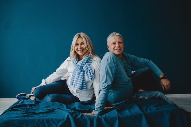 Vader en zijn volwassen dochter zitten samen op een blauw bed