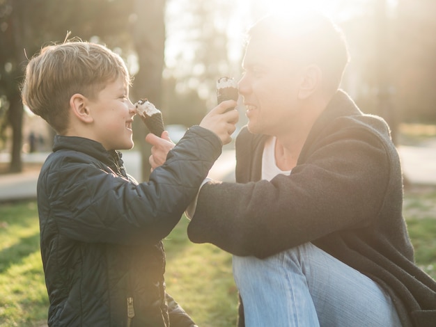 Vader en zoon die roomijs middelgroot schot eten