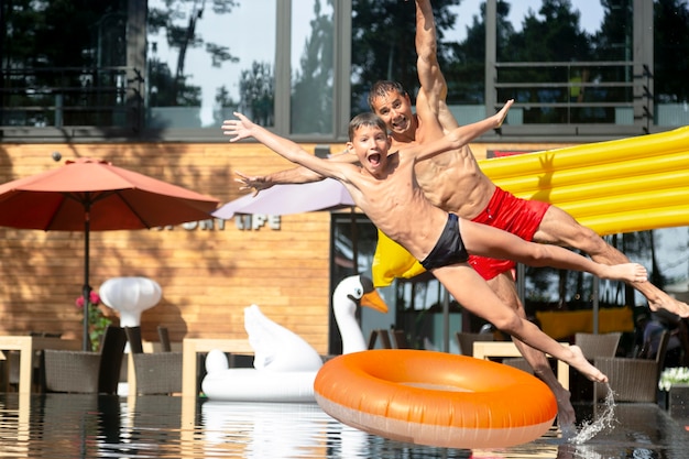 Gratis foto vader en zoon genieten samen van een dagje aan het zwembad