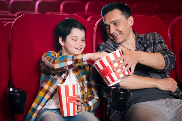 Vader en zoon kijken naar film in de bioscoop