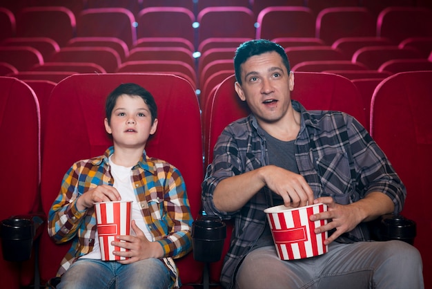 Vader en zoon kijken naar film in de bioscoop