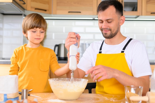 Vader en zoon maken deeg met de mixer