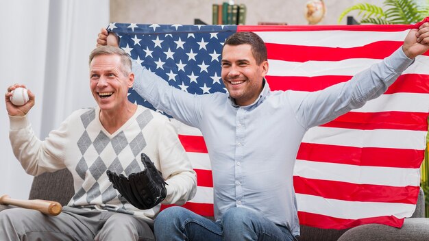 Vader en zoon met honkbal spullen en vlag