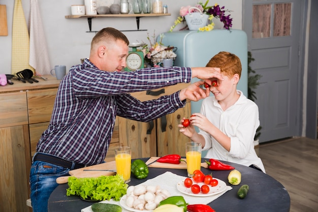 Gratis foto vader en zoon poseren in de keuken