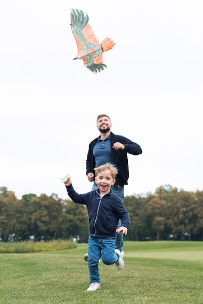 Vader en zoon spelen met vlieger vooraanzicht